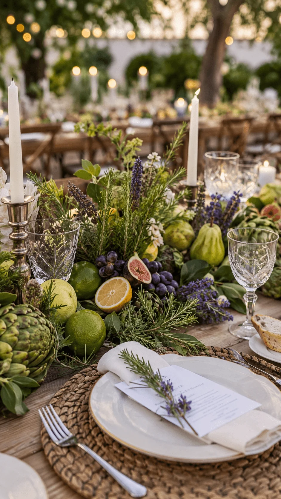 Rustic outdoor wedding tablescape with fresh fruits herbs lavender candles crystal glassware and woven placemats creating an elegant edible decor display under warm string lights