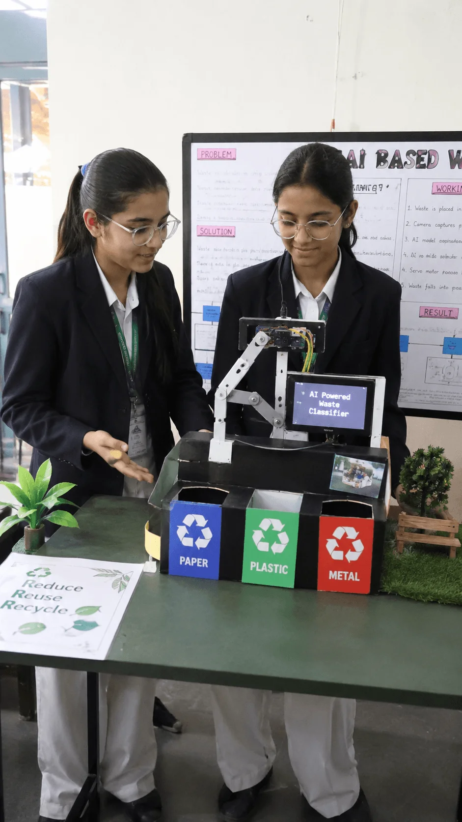 High school students presenting an AI powered waste classification system that sorts paper, plastic, and metal into separate recycling bins for sustainable waste management