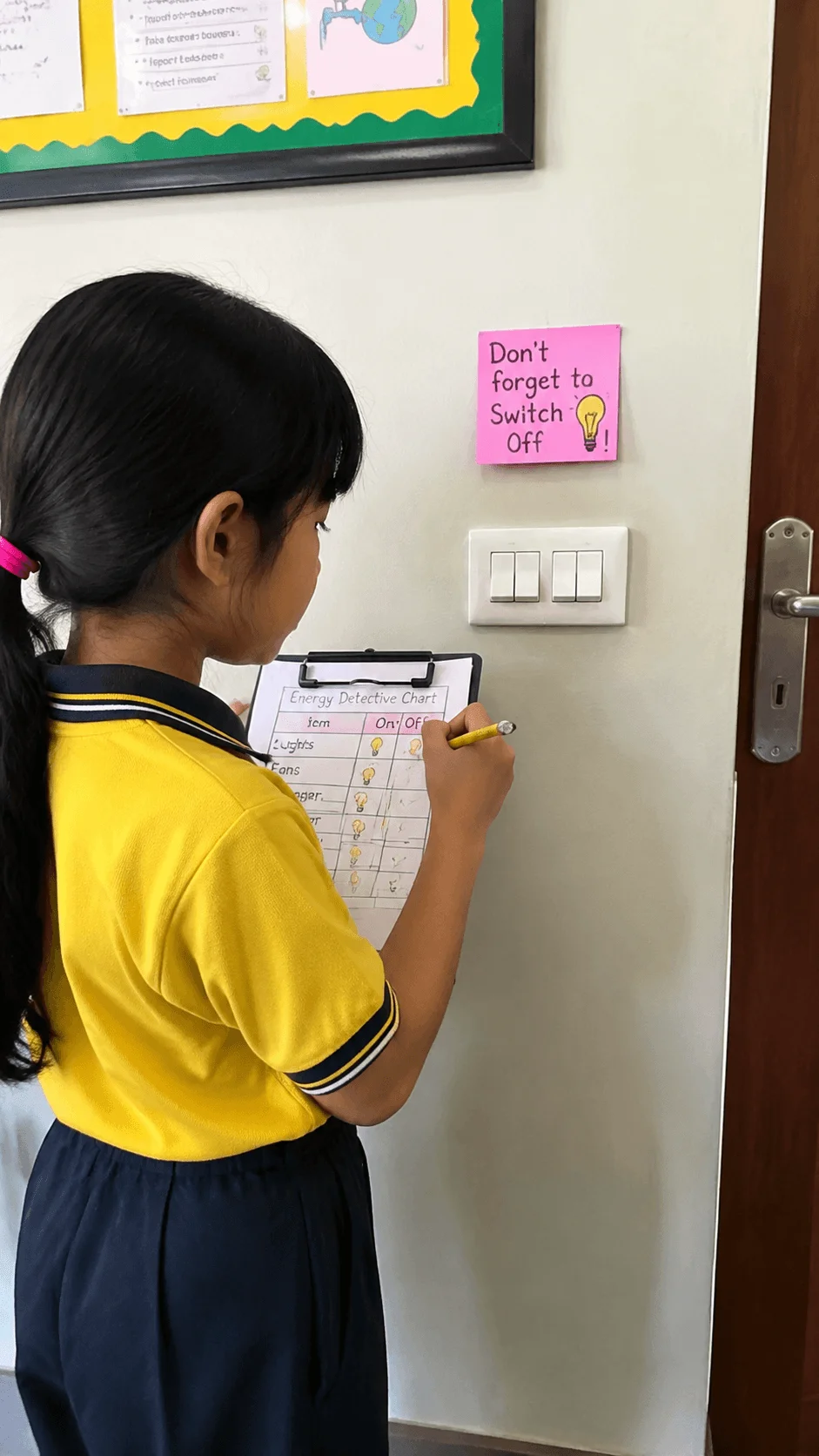 Child checking energy usage with an energy detective chart while learning to save electricity by switching off lights and appliances