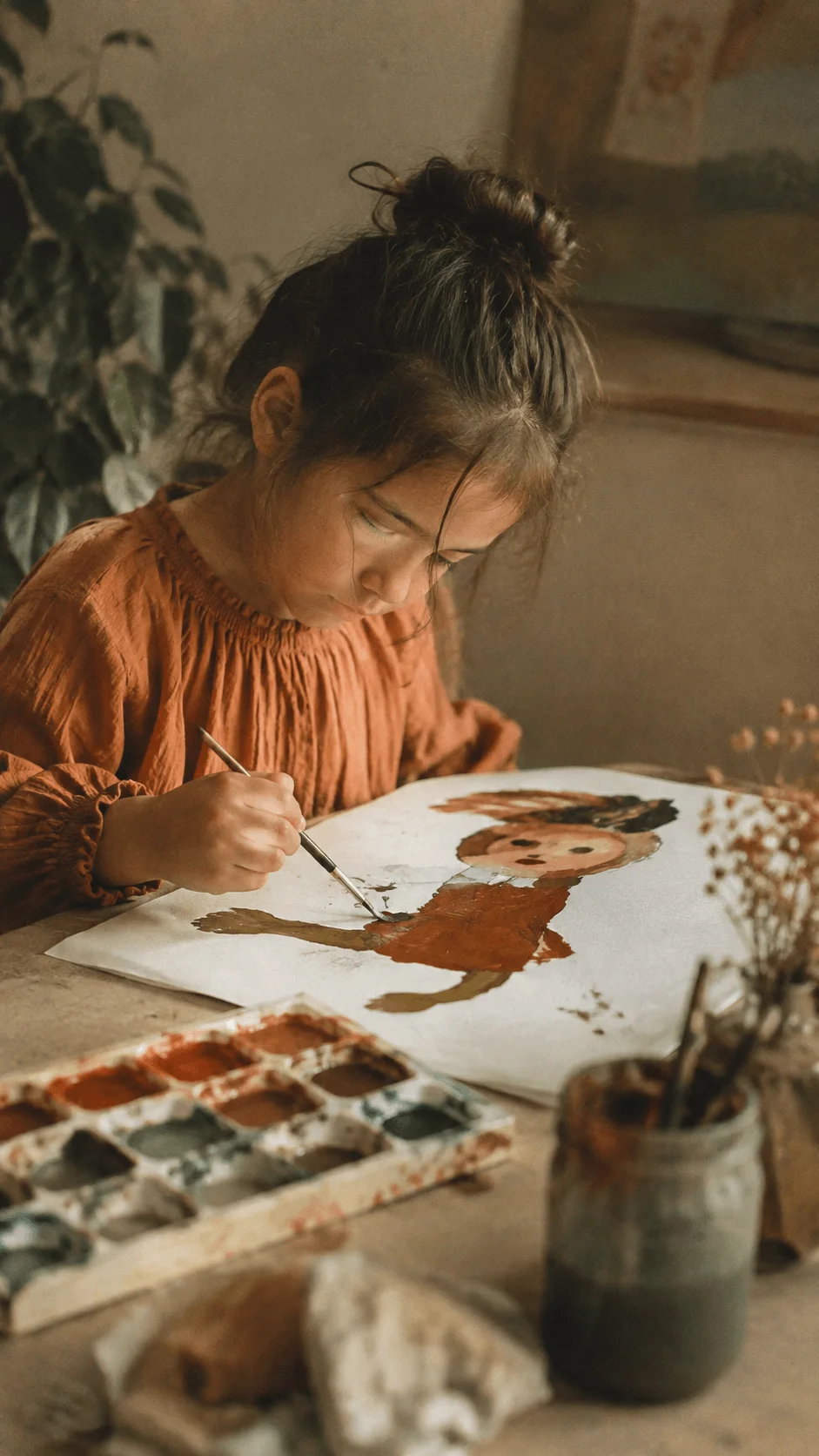 Analog inspired eco art photography with a child painting a nature themed portrait using earthy watercolor tones