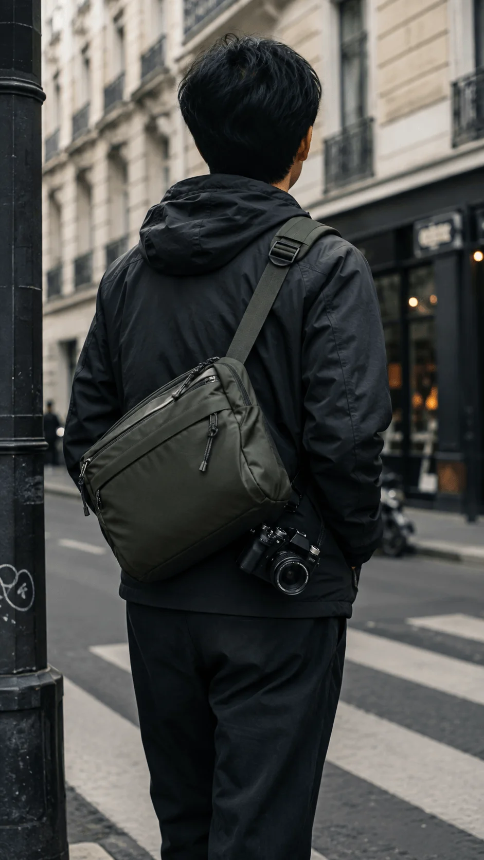 Compact eco friendly camera sling bag with a camera worn by a photographer on a city street