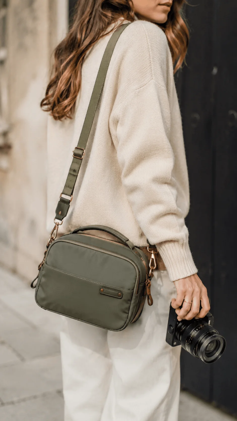 Fashion inspired sustainable camera bag worn with a camera in a minimalist street setting