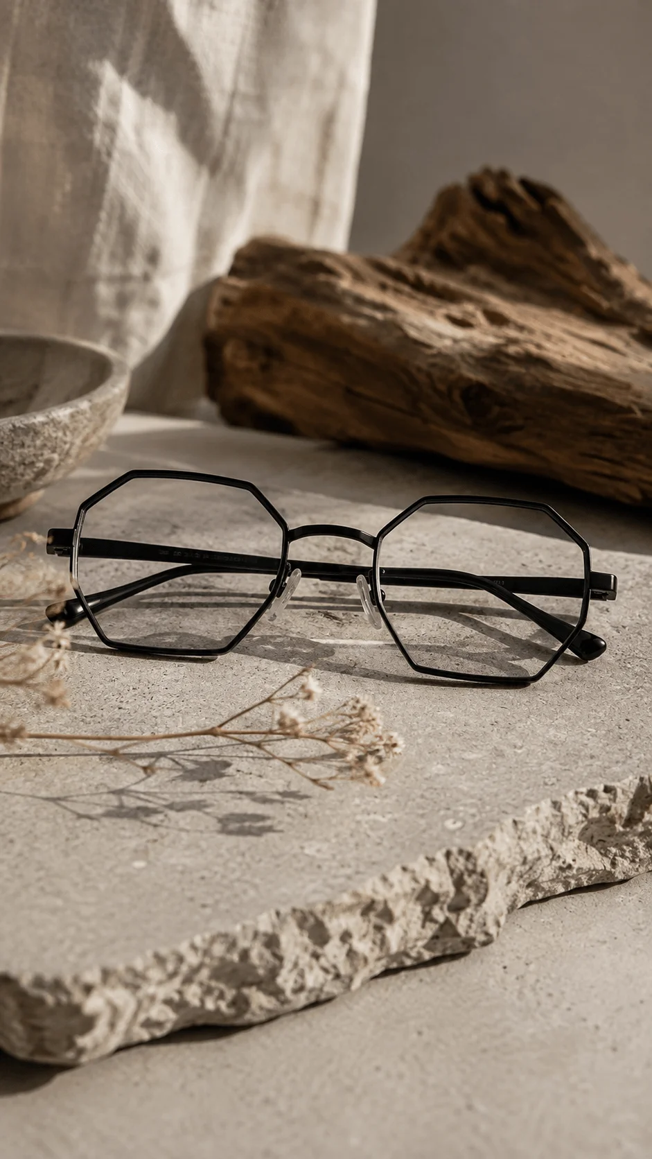 Geometric eco friendly black frames displayed on a textured stone surface with dried flowers and natural wood decor