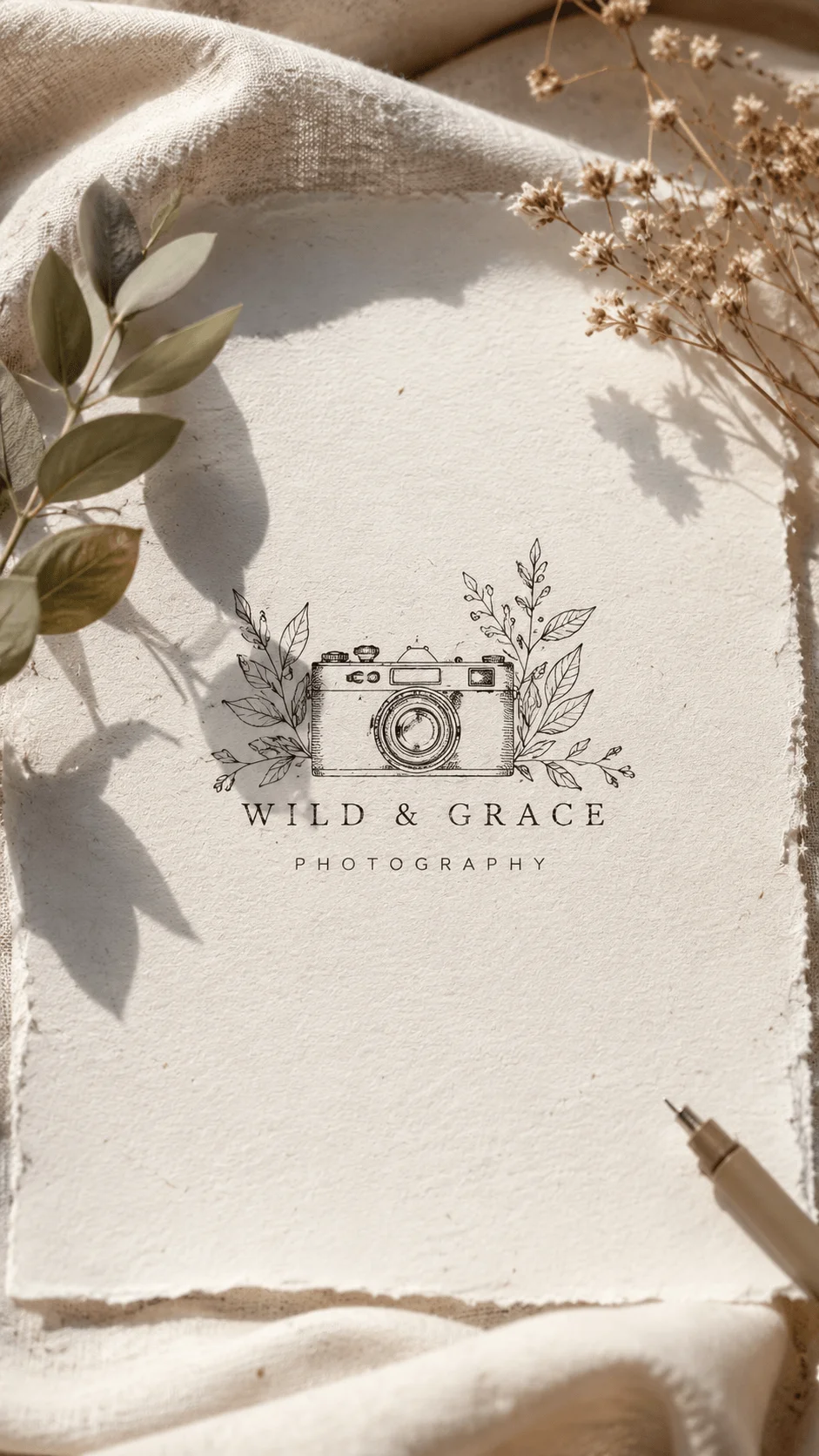 Hand drawn sustainable photography logo featuring a vintage camera surrounded by botanical leaves and elegant typography on textured handmade paper with natural shadows
