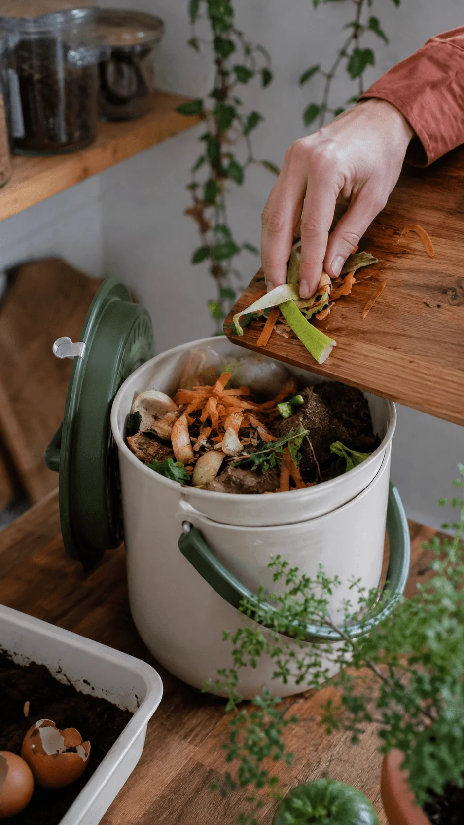 Small space composting at home with food scraps being added to a countertop compost bin